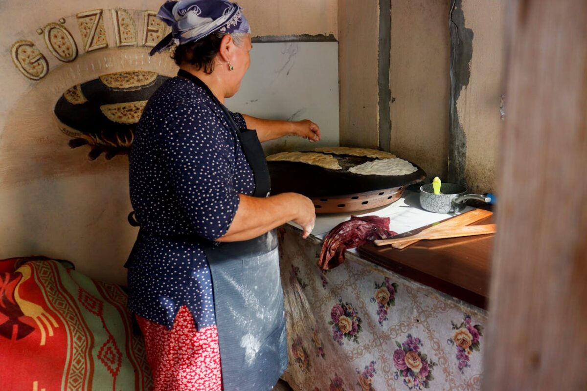 Elderly woman prepares traditional Turkish gözleme indoors in Anadolufeneri, Istanbul.