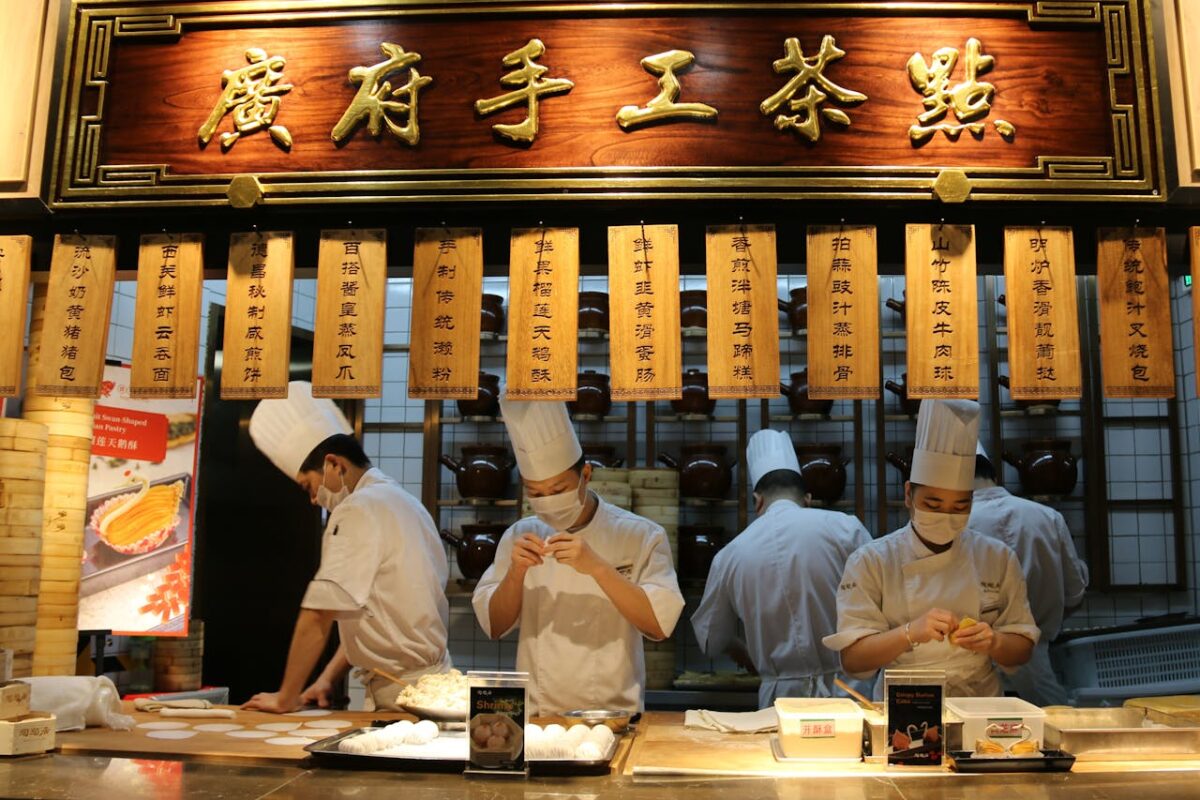 Talented chefs in action at a Chinese restaurant, preparing authentic dishes in an open kitchen.