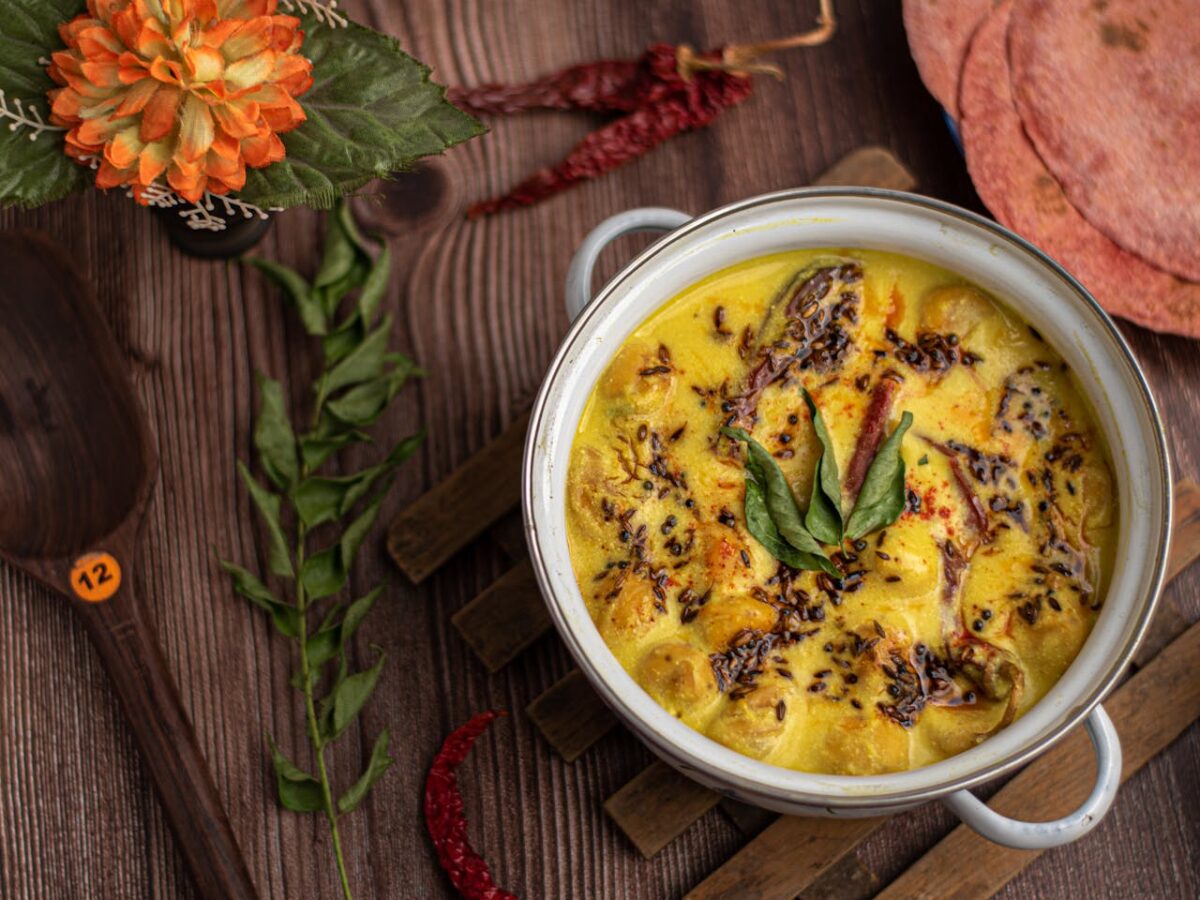 Savor the flavors of a traditional curry dish served in a colored ceramic bowl, garnished with herbs and spices.